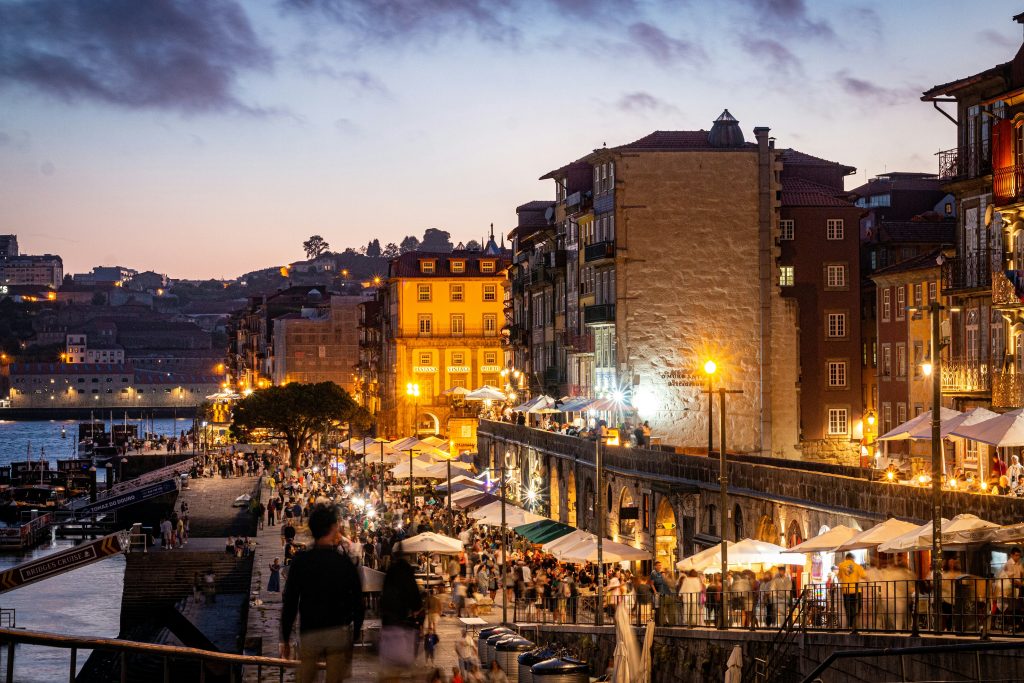 Porto City at night near river (ribeira area) with people walking on the street