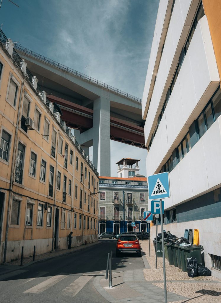 Lisbon street with cars parked and garbage bins